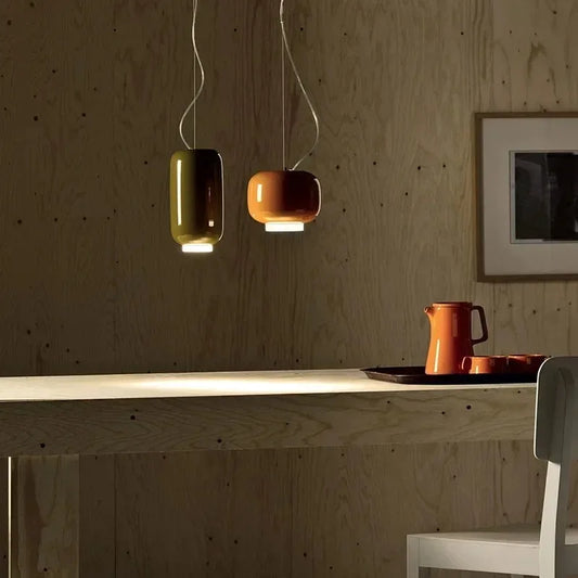 Red glass pendant lights hanging over a minimalist kitchen island.