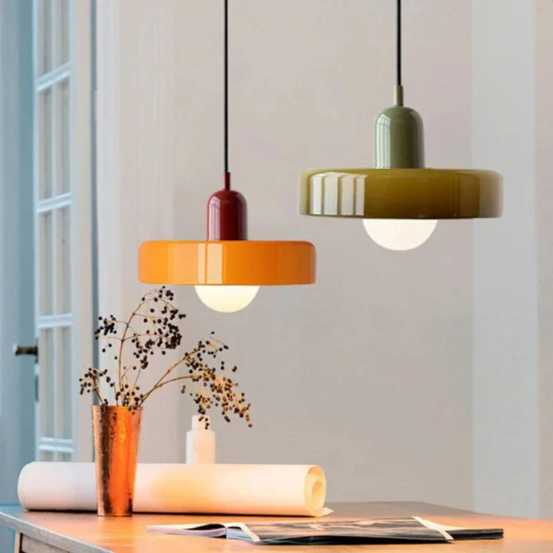 Two colorful pendant lights hanging above a table with decorative items.
