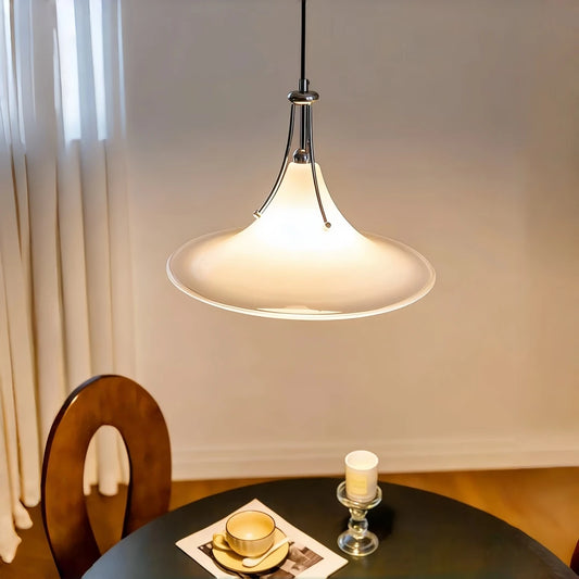 Flared glass pendant light hanging over a dining room table