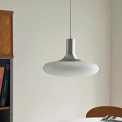 Glass pendant lights hanging at adjustable heights in a minimalist dining room.