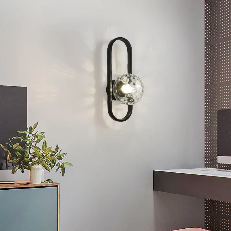 Modern wall sconce with glass shade in a room setting