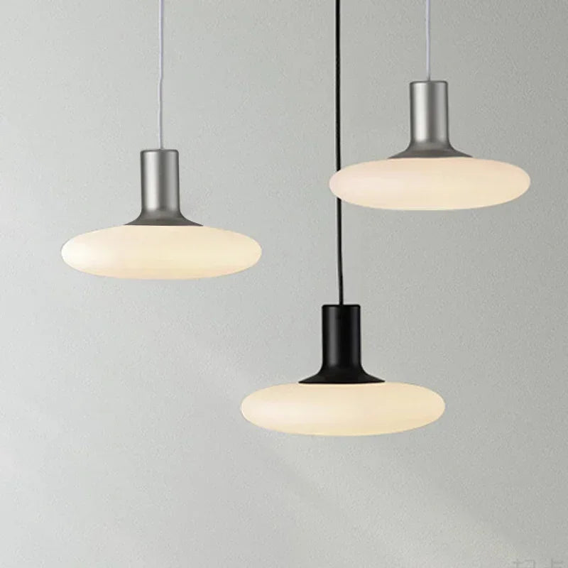 Modern pendant lights with milky glass globe and Spanish designer influence for parlors.