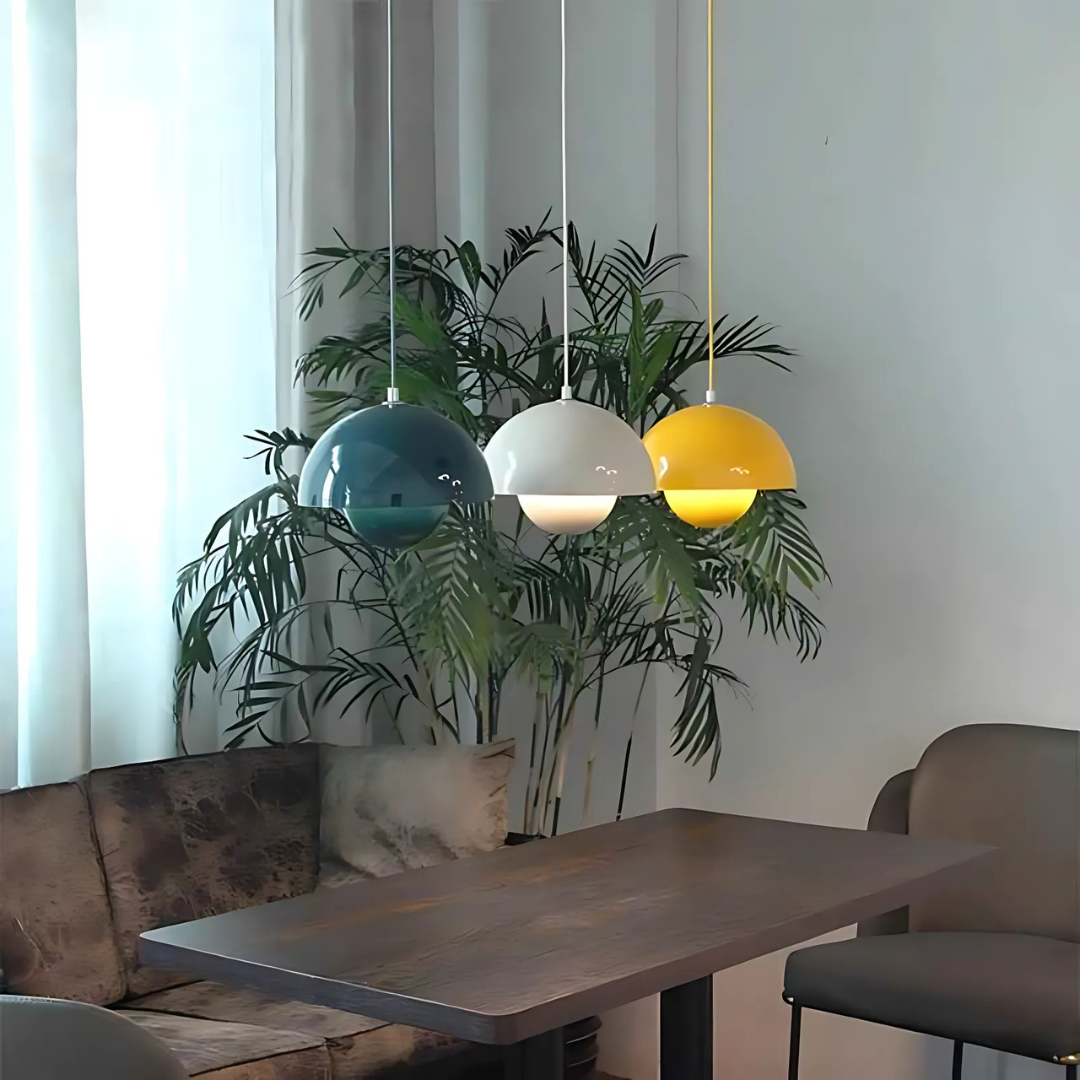 Nordic Bauhaus pendant lights in yellow, white, and blue hanging above modern dining space