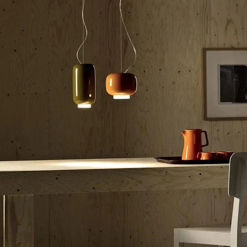 Red glass pendant lights hanging over a minimalist kitchen island.