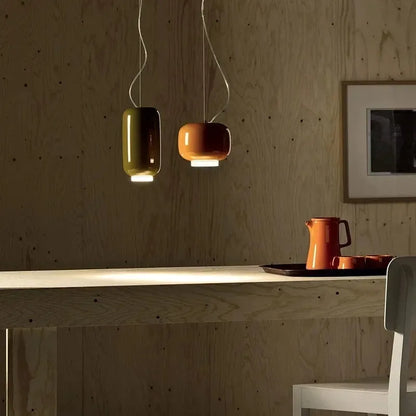 Red glass pendant lights hanging over a minimalist kitchen island.