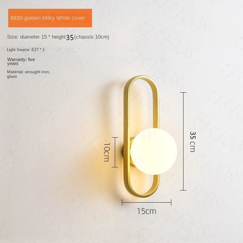 Wall lamp with gold fixture and white glass shade on a light gray background