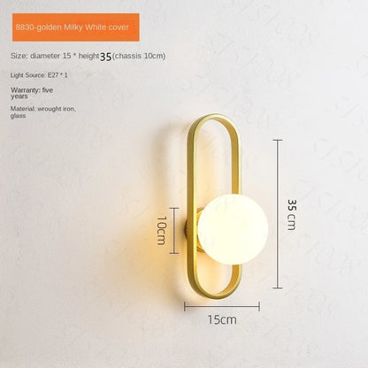 Wall lamp with gold fixture and white glass shade on a light gray background