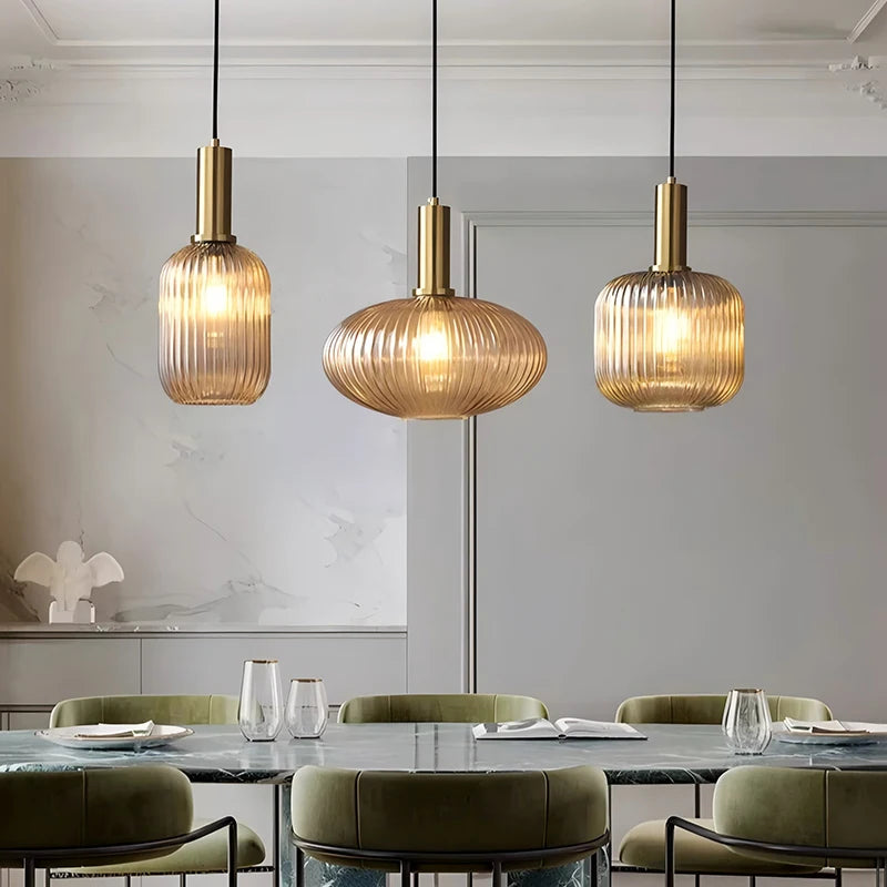 Modern dining room with three pendant lights hanging above a table.