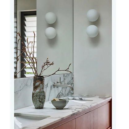Sleek bathroom design with white globe wall lamp